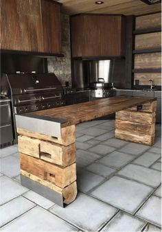 a large wooden table sitting in the middle of a kitchen next to a stove top oven