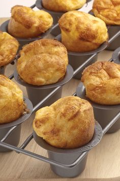 several muffins sitting in pans on top of a wooden table next to each other