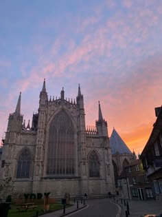 the sun is setting in front of an old cathedral