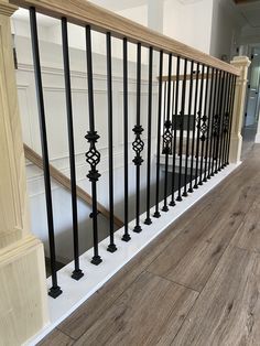 a wooden floor with black iron railings and wood hand rails on the bottom level