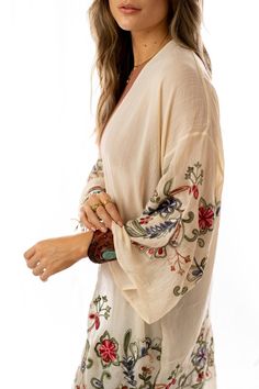 Nothing is more fun than a kimono covered in floral! This perfect layering piece features a sheer fabric in a longline silhouette with accents of crochet florals in multicolors along the hem and wide sleeves.Model is 5'8" and wearing one size.100% Polyester, Imported. OS sizing fits most* sizes US 0-18Length: 38 inBust Across: 25 inSleeve Length: 17 inSleeve Opening: 11 in Bohemian Sheer V-neck Cover-up, Bohemian Flowy Long Sleeve Kimono, Embroidered V-neck Kimono For Spring, Beige Floral Print Beach Kimono, Beige Long Sleeve Kimono For Festivals, Beige Kimono With Long Sleeves For Festivals, Bohemian Fall Kimono With Floral Embroidery, Summer Bohemian Long Sleeve Kimono, Summer Cream Long Sleeve Kimono