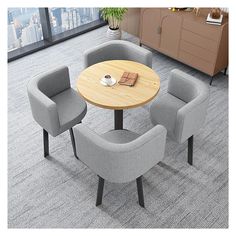 a table with four chairs around it in an office setting on carpeted flooring