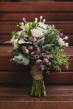 a bouquet of flowers sitting on top of a wooden table next to a brown wall