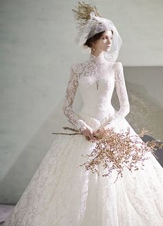 a woman in a wedding dress with flowers on her head and veil over her head