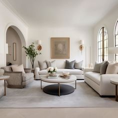 a living room filled with lots of white furniture and decor on top of carpeted flooring