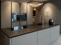 a modern kitchen with stainless steel appliances and marble counter tops, along with an island in the middle