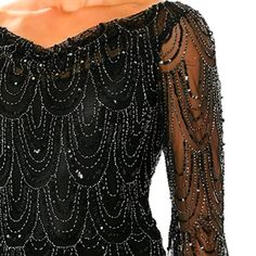 the back of a woman's black dress with beading and sequins