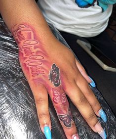 a woman's hand with butterfly tattoos on it