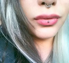 a close up of a person with piercings on their nose