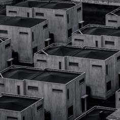 black and white photograph of many buildings made out of concrete blocks with windows on each side