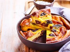 a pan filled with pizza on top of a wooden table