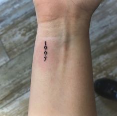 a woman's wrist with a small tattoo that reads, i love 1971 on it