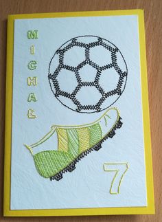 a card with an embroidered soccer ball on it and the number seven in front of it