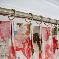 colorful floral curtains hanging from a metal rod