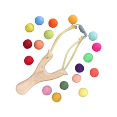 an assortment of colored balls and a wooden toy with a long string attached to it