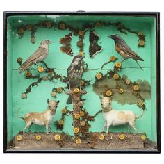 a group of animals and birds on display in a green box with flowers all over it