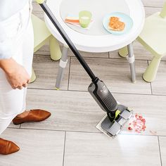 a person is cleaning the floor with a vacuum