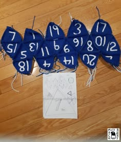 several pieces of blue cloth with numbers on them sitting next to a piece of paper