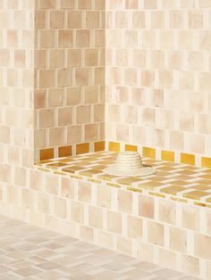 a white hat sitting on top of a wooden table next to a tiled bathroom wall