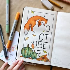 an open notebook with the words october written in it and some markers, pencils, and crayons