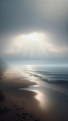 the sun shines through clouds over an ocean beach with footprints on the sand and water