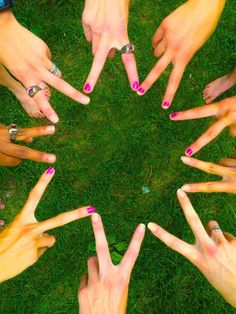 many hands are arranged in the shape of a circle with pink and white nail polish