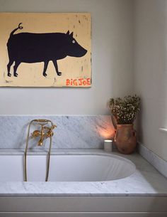 a bathroom with a bathtub and painting on the wall