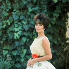 a woman in a white and yellow dress posing for the camera