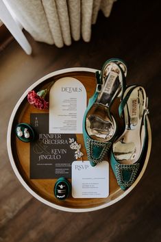 wedding shoes and stationery laid out on a round table with the bride's details