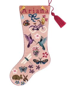 a cross stitch christmas stocking with birds and flowers on it, hanging from a red tassel