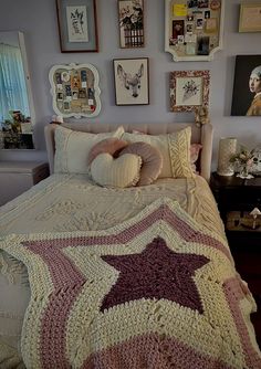 a bed with a crocheted star on the cover and pillows in front of it