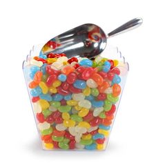 a plastic container filled with lots of gummy bears and a spoon on top of it