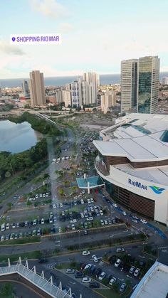 an aerial view of a shopping mall with cars parked in the lot and tall buildings