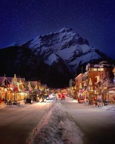 an image of a snowy town at night with mountains in the background and snow on the ground