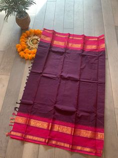 These Kanchi sarees are known for their tradition, comfort and simplicity. The saree is handwoven and comes with an intricately woven border. This saree comes in eggplant shade with pink border and a running blouse piece.  Pico, falls and blouse stitching can be done at an extra cost. Festive Saree With Border For Rituals, Traditional Drape Saree With Border For Rituals, Traditional Wear With Border For Diwali Rituals, Traditional Wear For Diwali With Border Details, Traditional Wear For Diwali Rituals With Border Details, Rituals Saree With Border, Traditional Saree With Border For Rituals, Anarkali Style Saree With Weaving Work For Puja, Traditional Saree For Rituals With Border Detail