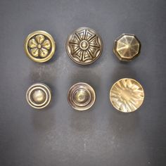 six different types of buttons on a table top with one being turned to look like an ornament