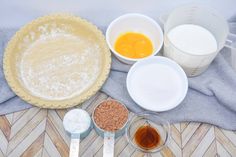 ingredients for pie laid out on a towel next to measuring cups and bowls with eggs in them