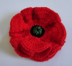 a crocheted red flower with a black center