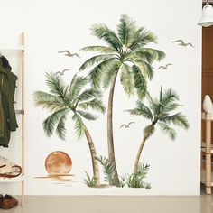 a palm tree painted on the side of a wall next to a coat rack and shoes