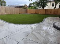 an empty backyard with grass in the middle