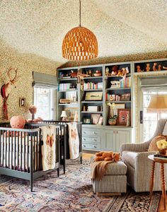 a baby's room with a crib, rocking chair and bookcases