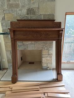 an empty fireplace in a room with wood flooring on the ground next to it