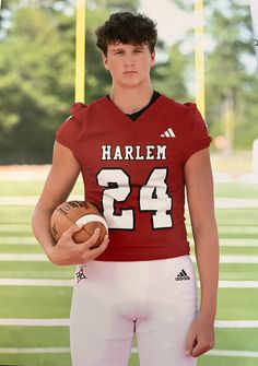 a young man holding a football on top of a field