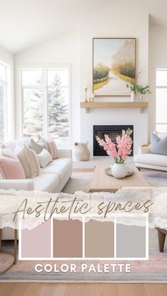 a living room with white couches and pink flowers on the coffee table in front of a fireplace