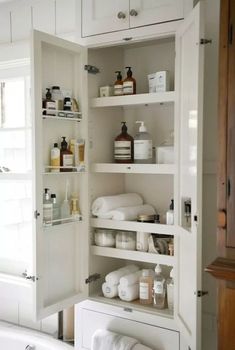 an open medicine cabinet in a bathroom next to a bathtub