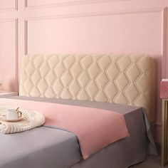 a bedroom with pink walls and a white headboard on top of a gray bed