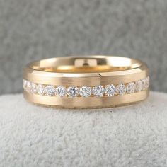 a yellow gold wedding band with three rows of diamonds on the inside and outside of it