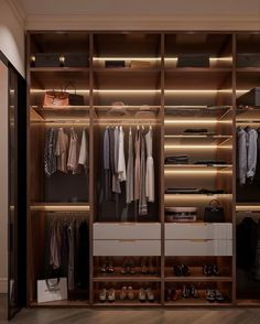 a walk in closet with lots of clothes and shoes on the shelves next to it