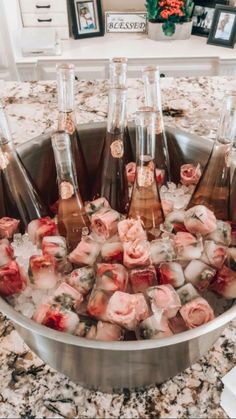 a metal bowl filled with lots of ice and wine bottles