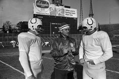 three football players are talking on the field